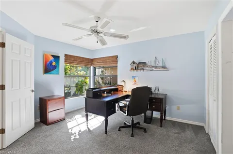 a view of a workspace with furniture and a window