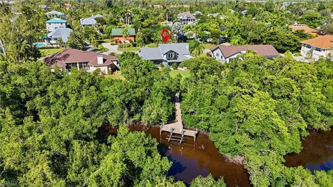 an aerial view of residential houses with outdoor space and trees