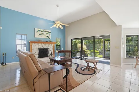 a living room with furniture a fireplace and floor to ceiling windows
