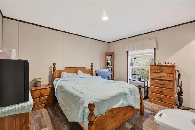 a bedroom with bed and wooden floor