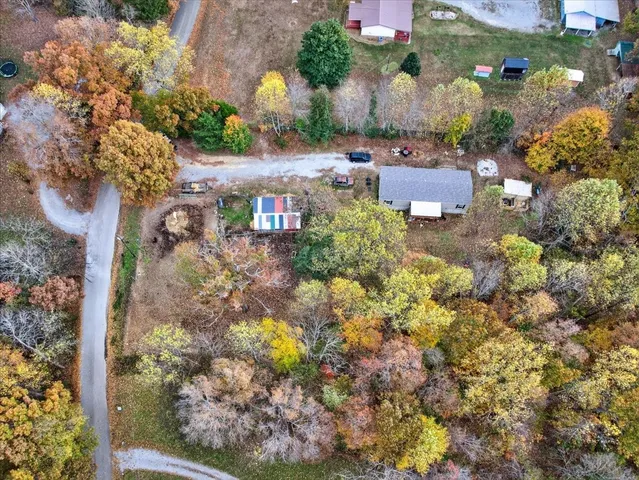 a room with stainless steel appliances kitchen island granite countertop a dining table chairs refrigerator and a sink