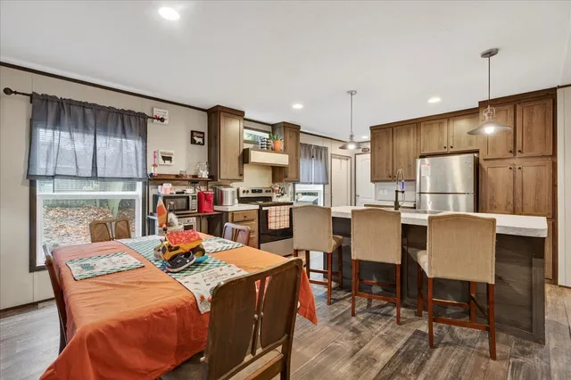 a living room with furniture kitchen view and a chandelier