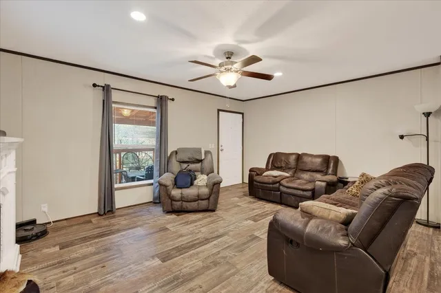 a living room with furniture a fireplace and a ceiling fan