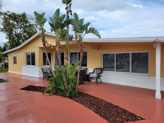 a front view of a house with a garden and patio