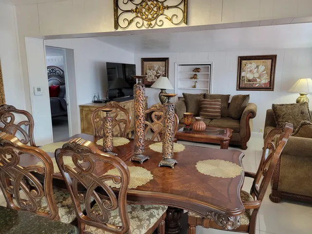 a living room with furniture a flat screen tv and a table