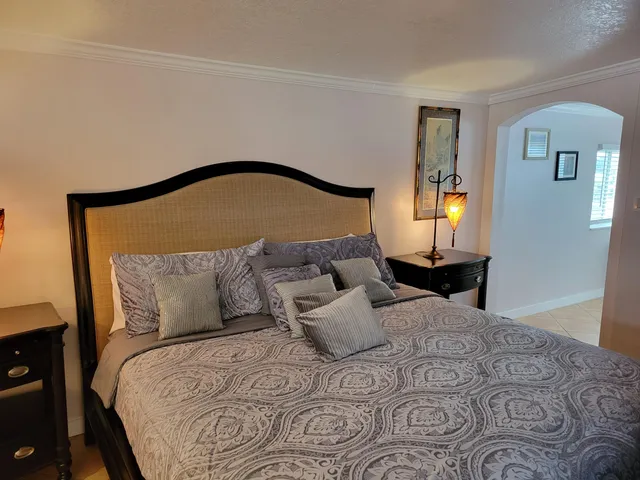 a bedroom with a large bed and a wooden floor