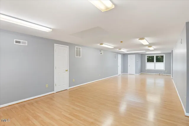 a view of empty room with wooden floor