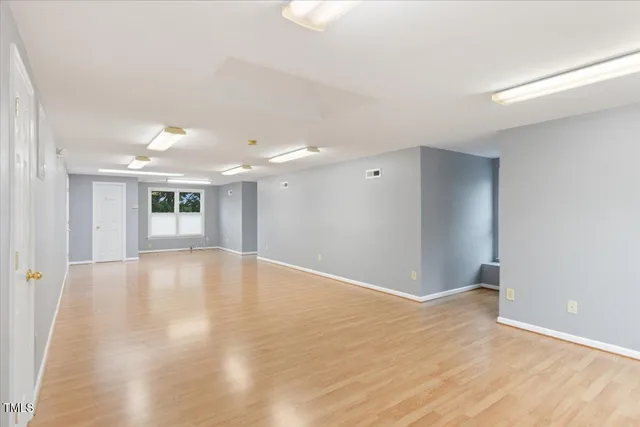 a view of empty room with wooden floor