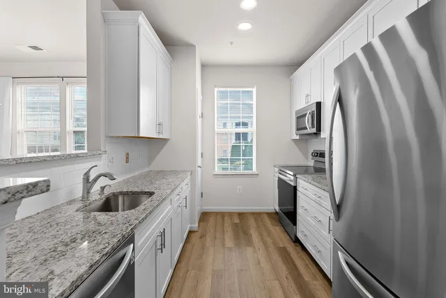 a kitchen with granite countertop a sink stove and refrigerator