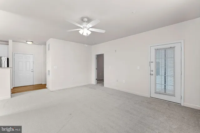 a view of an empty room with a chandelier fan