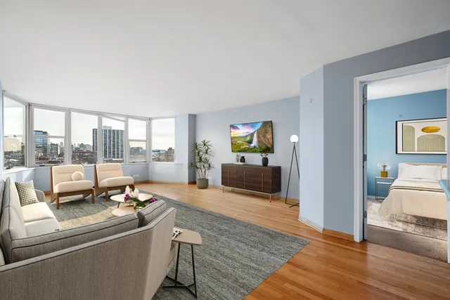 a view of a city from a patio with couches and table and chairs and potted plants