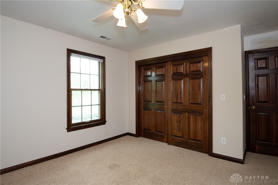 9981 Ridge Acres Lane Englewood, OH 45322 - Photo 31 of 73 This spacious bedroom offers ample natural light and comfortable carpeting, perfect for relaxation.