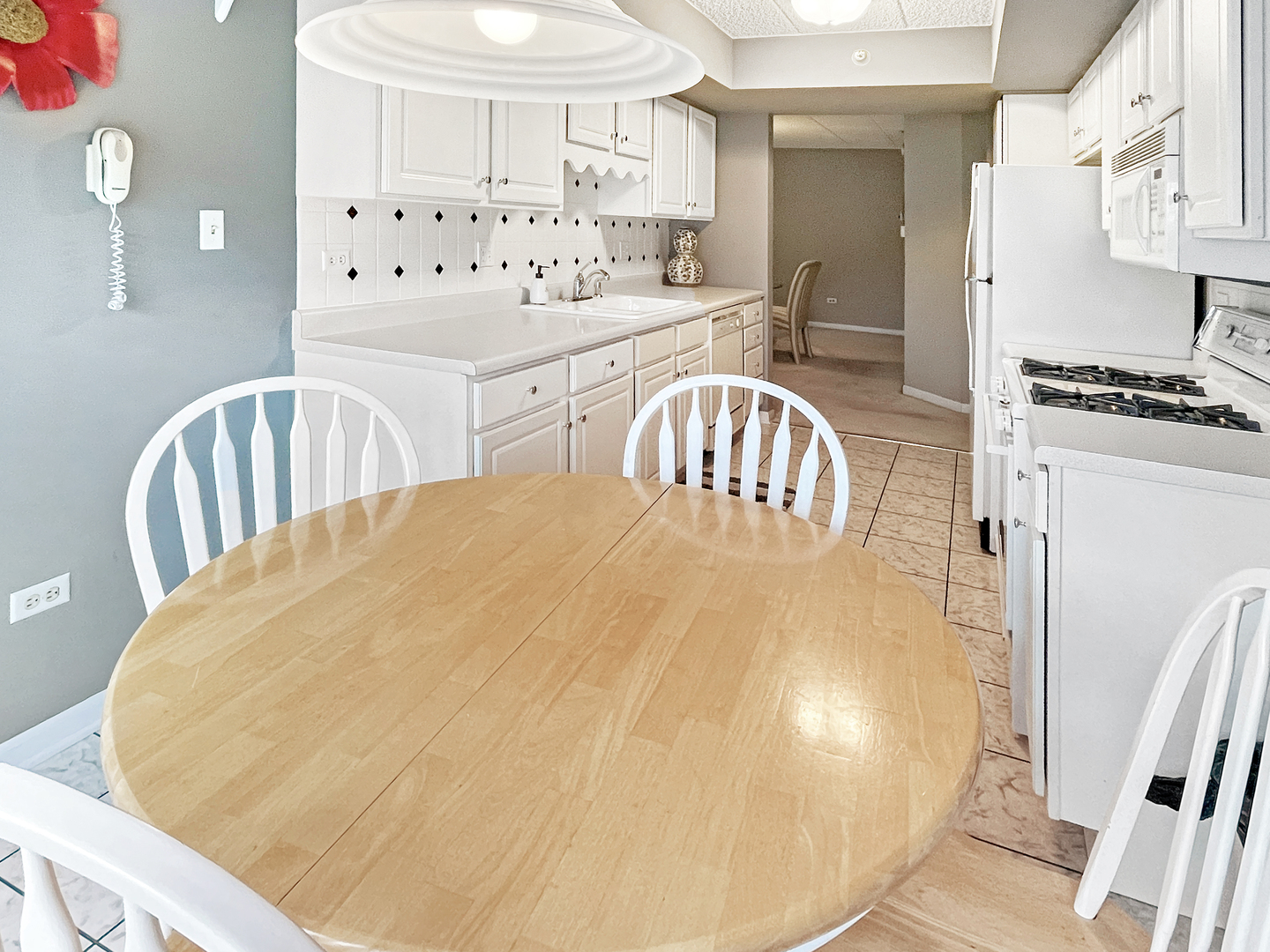 3640 186th Street, Unit 201 Lansing, IL 60438 - Photo 8 of 21 a kitchen with granite countertop a white refrigerator a stove a sink a dining table and chairs with wooden floor