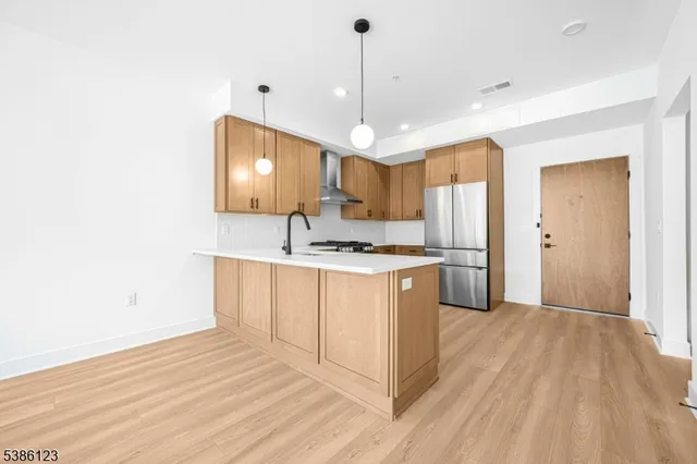 a kitchen with a refrigerator a sink and cabinets