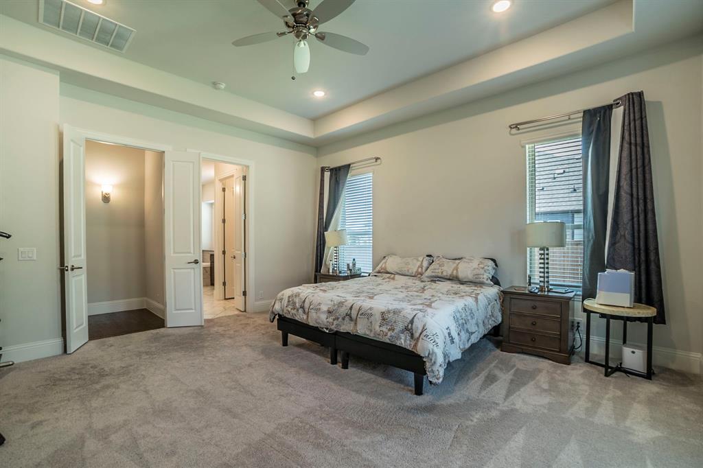 1420 Ashton Ridge Drive Prosper, TX 75078 - Photo 11 of 39 a spacious bedroom with a bed and a chandelier