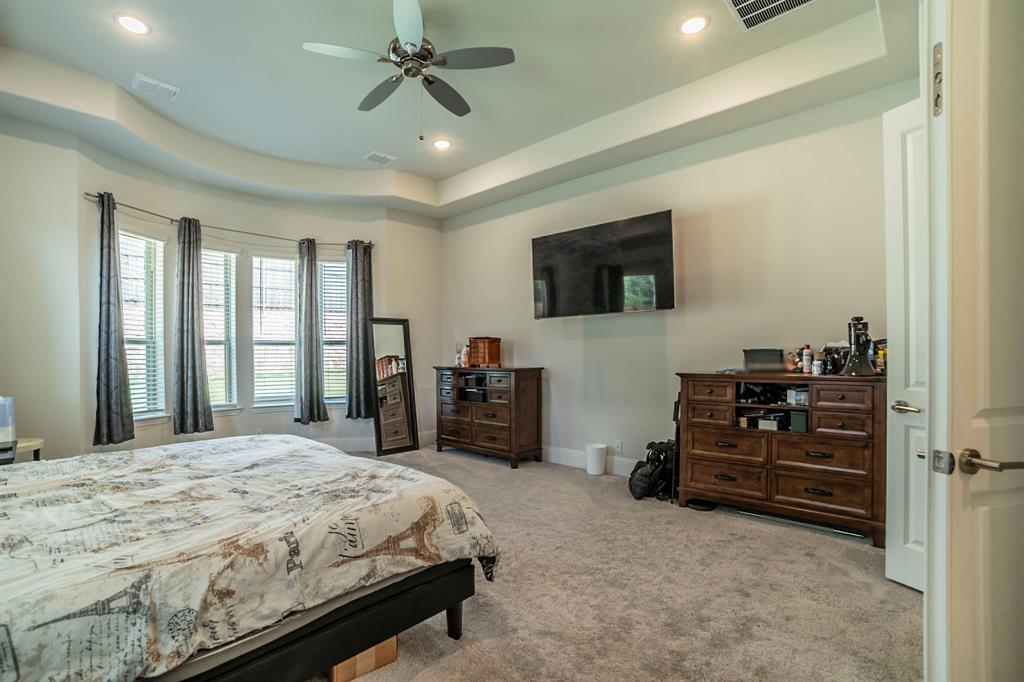 1420 Ashton Ridge Drive Prosper, TX 75078 - Photo 12 of 39 a bedroom with a bed and a flat screen tv