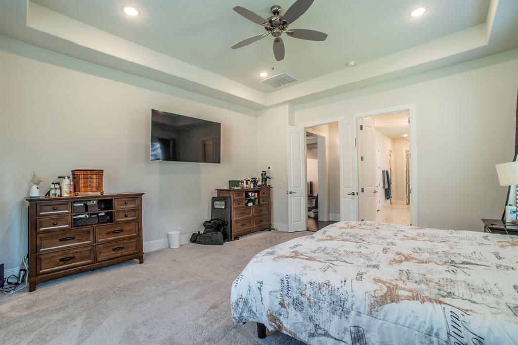 1420 Ashton Ridge Drive Prosper, TX 75078 - Photo 13 of 39 a bedroom with a bed and a flat tv screen on wall