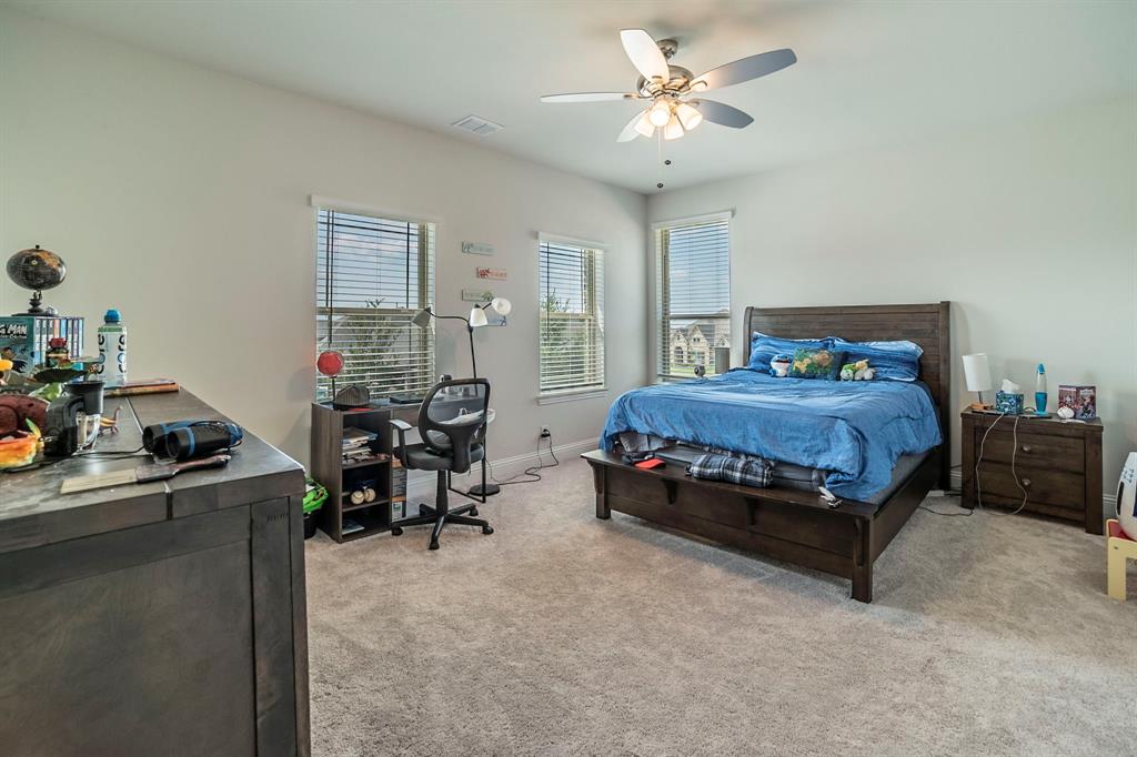 1420 Ashton Ridge Drive Prosper, TX 75078 - Photo 16 of 39 a bedroom with bed and a chandelier