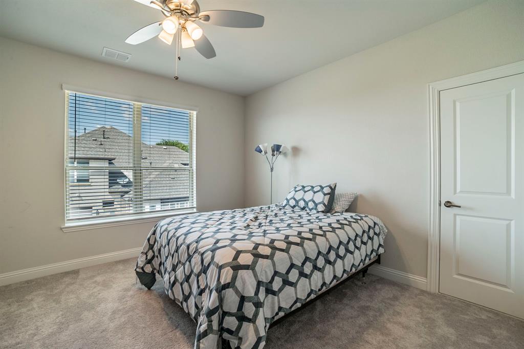 1420 Ashton Ridge Drive Prosper, TX 75078 - Photo 26 of 39 a bedroom with a bed and a chandelier
