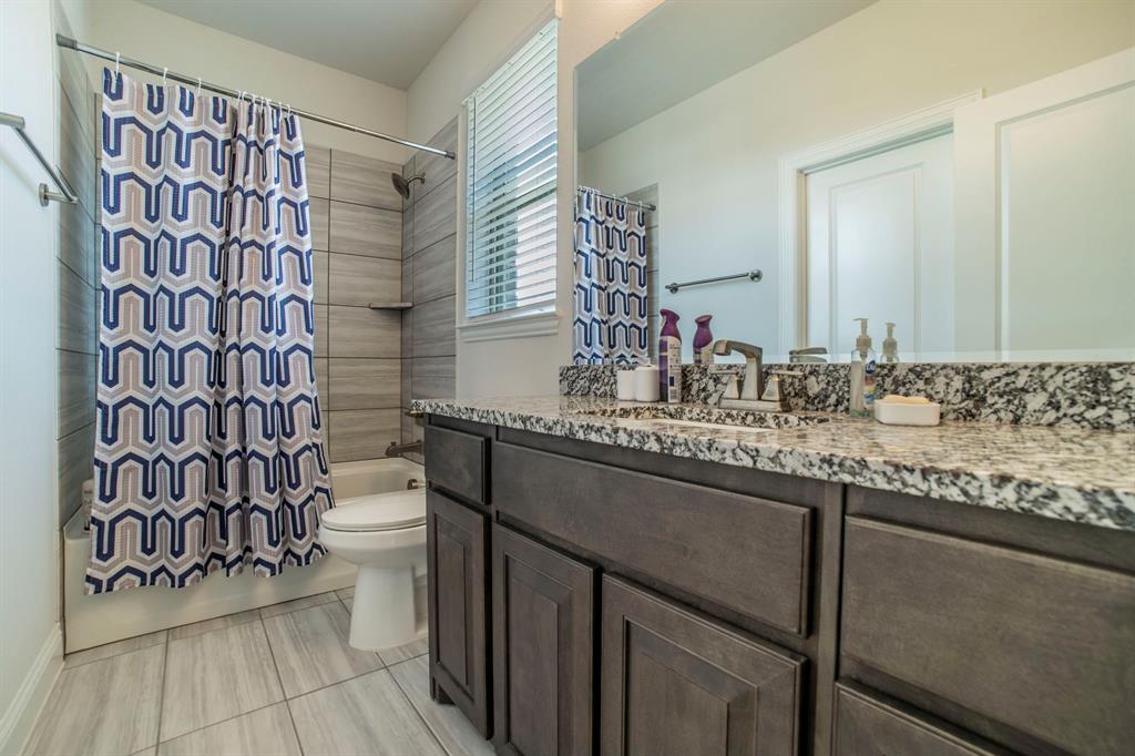 1420 Ashton Ridge Drive Prosper, TX 75078 - Photo 28 of 39 a bathroom with a granite countertop sink a mirror and shower