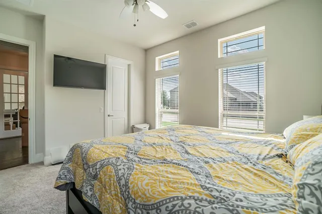 a bedroom with a bed a television and a window