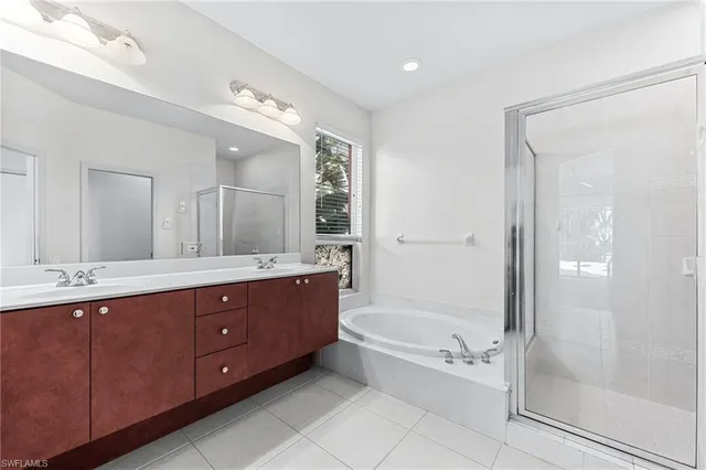 a bathroom with a tub a sink shower and mirror