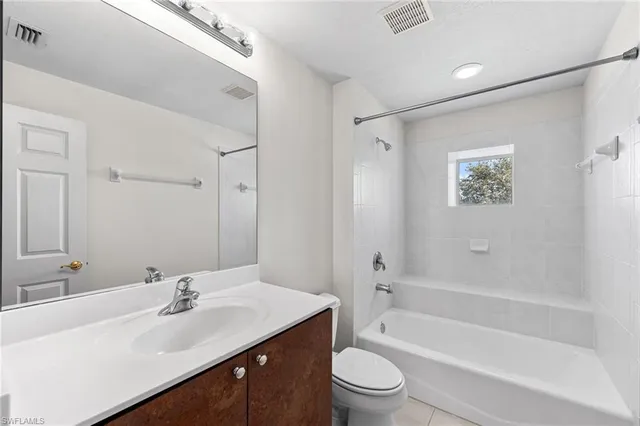 an empty room with a ceiling fan and window