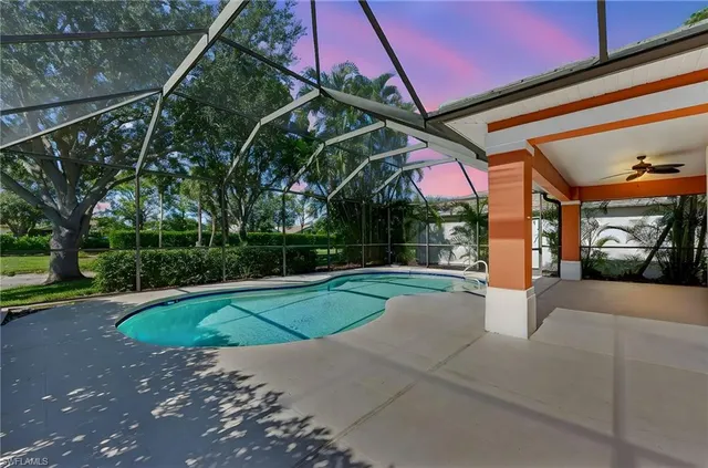 a swimming pool on a sunny day with lawn chairs