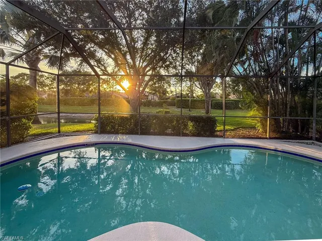 a view of a yard in front of a house with a large tree