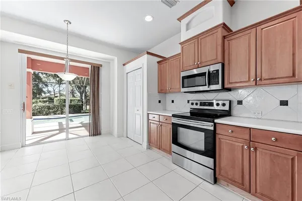 a kitchen with stainless steel appliances granite countertop a stove a sink and a microwave