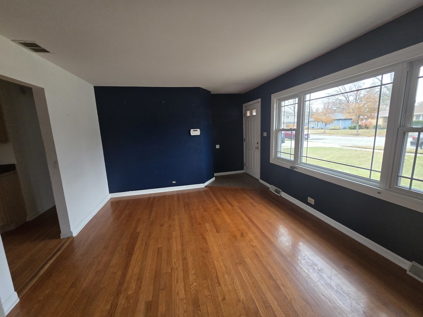6108 Birmingham Street Chicago Ridge, IL 60415 - Photo 3 of 19 a view of an empty room with wooden floor and a window