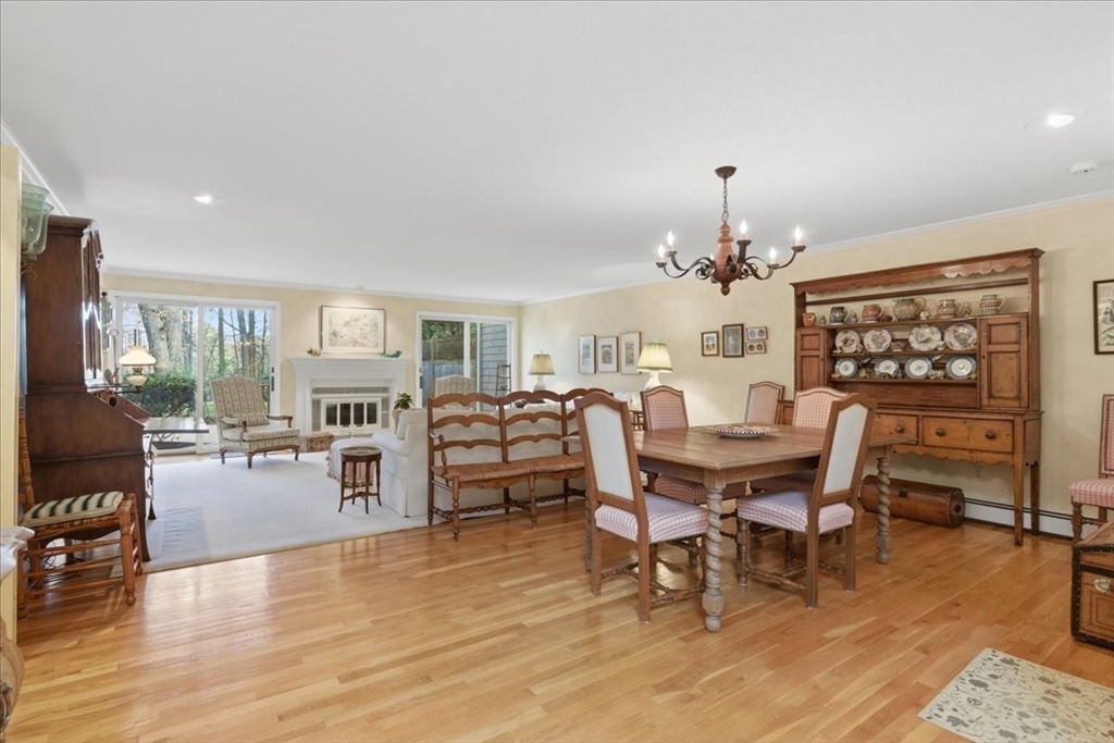 401 Dedham Street, Unit B Newton, MA 02459 - Photo 6 of 33 a dining room with wooden floor a chandelier a wooden table and chairs