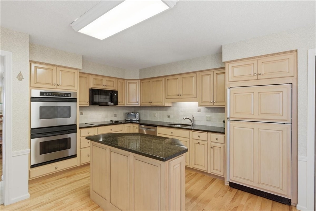 401 Dedham Street, Unit B Newton, MA 02459 - Photo 7 of 33 a kitchen with white cabinets and stainless steel appliances
