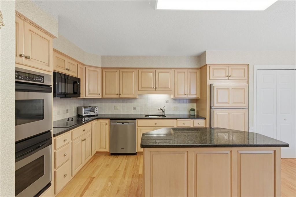 401 Dedham Street, Unit B Newton, MA 02459 - Photo 8 of 33 a kitchen with granite countertop white cabinets and white appliances