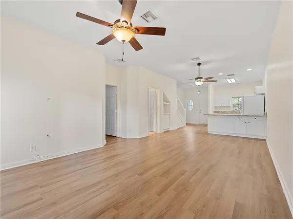 wooden floor in an empty room with a kitchen