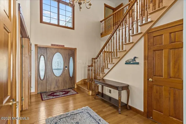 a view of entryway bedroom and hall with wooden floor