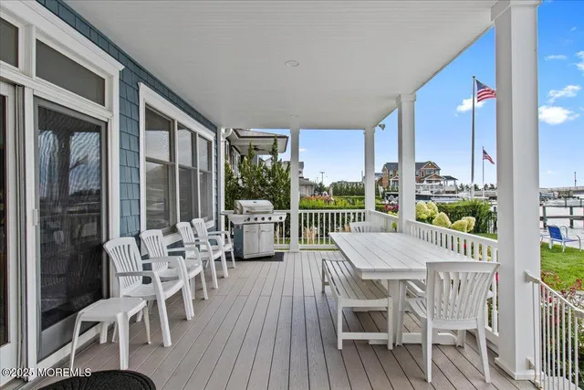 a view of a roof deck with table and chairs floor to ceiling window with wooden floor