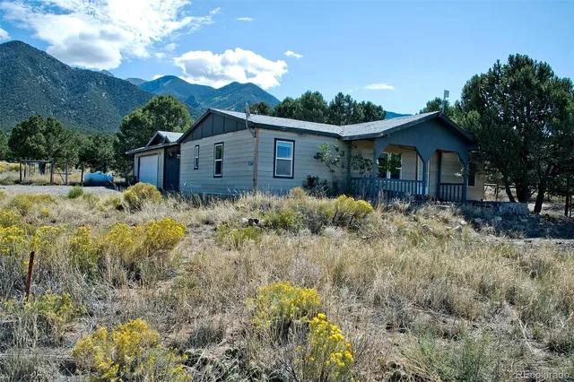 a view of a house with a yard covered with large trees