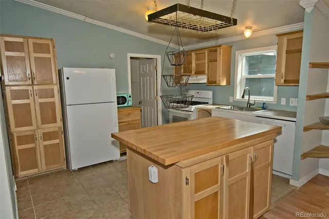 a kitchen that has a cabinets a sink and a refrigerator