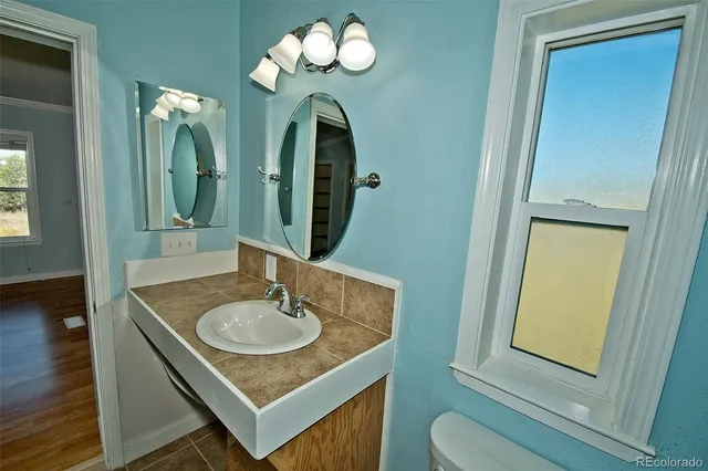 a bathroom with a granite countertop sink and a mirror