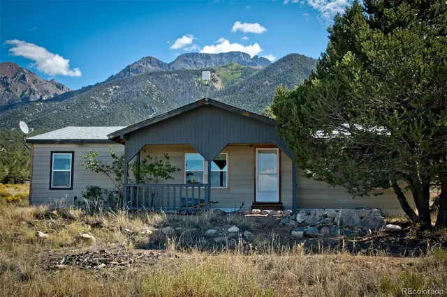 a front view of house with yard and trees around