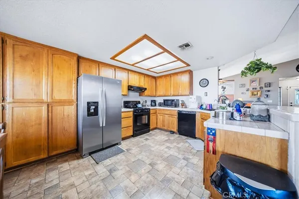 a kitchen with stainless steel appliances granite countertop a refrigerator a stove and a sink with cabinets