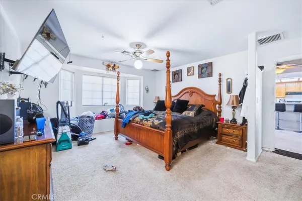 a bedroom with furniture a flat screen tv and a fireplace