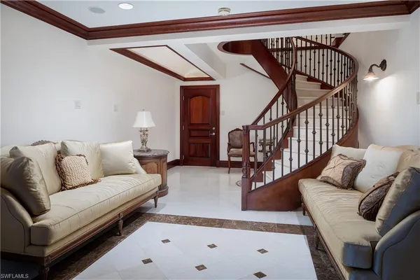 a living room with white couches and a dining table with wooden floor