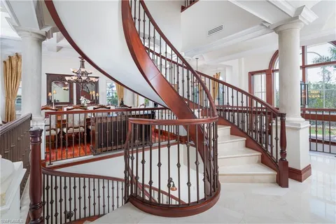a view of staircase with lots of frames and white walls