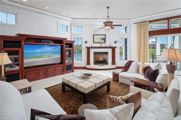 a living room with furniture a flat screen tv and a fireplace