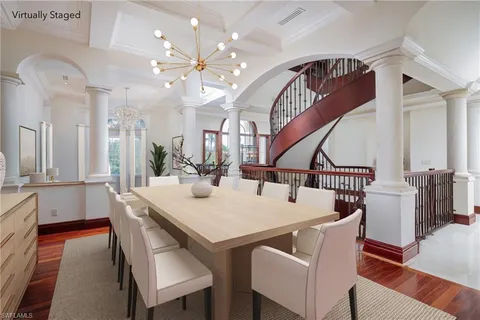 a view of a dining room and livingroom with furniture wooden floor and a chandelier