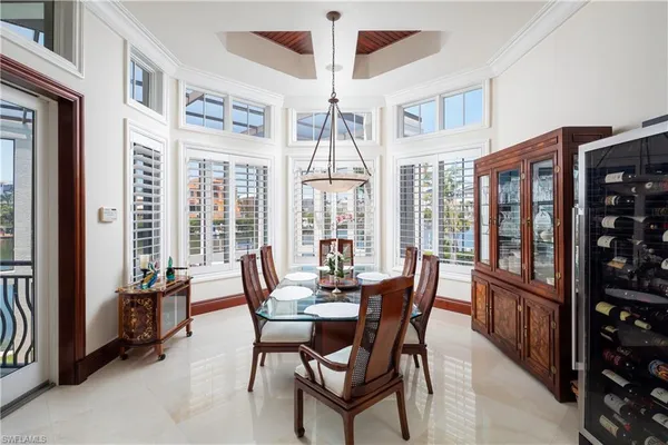 a dining room with furniture large windows and a chandelier