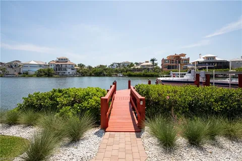 a view of a lake with a yard and potted plants