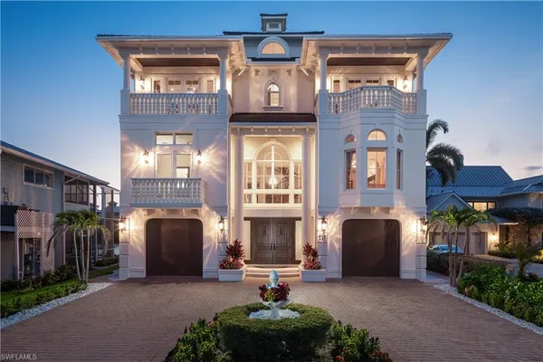 a front view of a house with many windows and yard